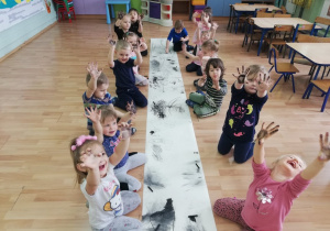 Dzieci pokazują brudne od węgla ręce.